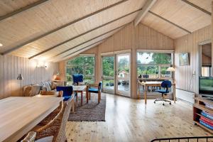 a living room with a wooden ceiling and windows at Family-Friendly Cottage Near The Beach in Gilleleje