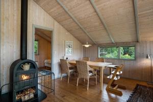 a dining room with a table and a wood stove at Family-Friendly Cottage Near The Beach in Gilleleje