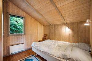 a bedroom with a bed in a wooden room at Family-Friendly Cottage Near The Beach in Gilleleje