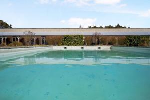 a large pool of blue water in front of a building at Cozy Holiday Apartment Close To The Beach in Neksø