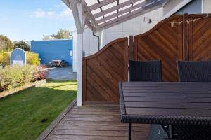 a wooden deck with a bench and a fence at Cozy Holiday Apartment Close To The Beach in Neksø