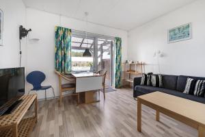 a living room with a blue couch and a table at Cozy Holiday Apartment Close To The Beach in Neksø