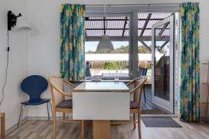 a kitchen and dining room with a table and chairs at Cozy Holiday Apartment Close To The Beach in Neksø
