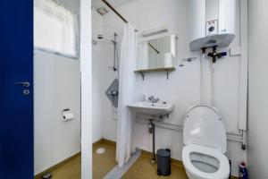 a bathroom with a toilet and a sink at Cozy Holiday Apartment Close To The Beach in Neksø +15 photos
