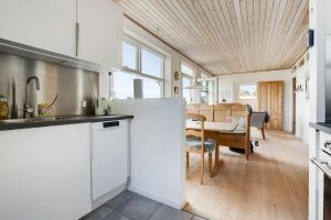 eine Küche mit weißen Schränken und ein Esszimmer in der Unterkunft Exklusive Lage Direkt Am Wasser in Kolding + 32 Fotos