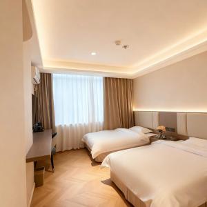 a hotel room with two beds and a window at Shenzhen Green Oasis Hotel, Baoan in Bao'an
