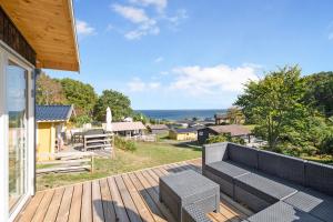 a patio with a couch on a wooden deck at Beautifully Situated Summer House With Sea View in Allinge