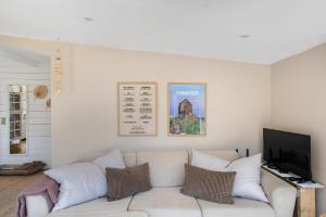 a living room with a white couch and a flat screen tv at Beautifully Situated Summer House With Sea View in Allinge