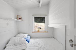 a small room with two beds and a window at Beautifully Situated Summer House With Sea View in Allinge