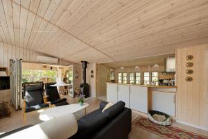 a living room with a couch and a table at Lovely Cottage In Recreation Area in Åkirkeby