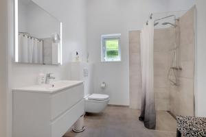 a white bathroom with a toilet and a shower at New And Cozy House By The Beach And Forest in Hornbæk +21 photos
