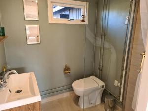 a bathroom with a toilet and a glass shower at Lovely Cottage Full Of Holiday Atmosphere in Rødby +11 photos