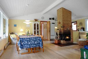 a living room with a table and a fireplace at Nice Summer House In The Middle Of The Forest in Store Fuglede +21 photos