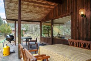 a porch of a wooden house with a table and chairs at Nice Summer House In The Middle Of The Forest in Store Fuglede
