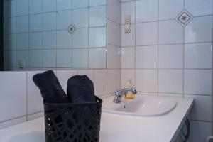 a bathroom with a sink and a basket with towels at Cozy Central Located Townhouse In Nakskov in Nakskov +32 photos