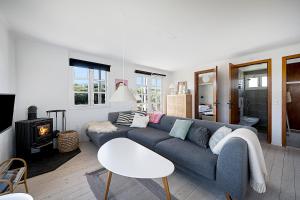 ein Wohnzimmer mit einem blauen Sofa und einem Kamin in der Unterkunft Gemütliches Ferienhaus Im Sommerdorf Kerteminde in Kerteminde