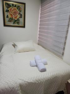 a bed with two towels on top of it at BED & Breakfast in Bogotá +10 photos