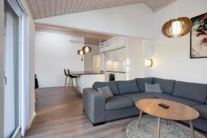 a living room with a couch and a table at Charming Cottage In Fjellerup With Indoor Spa in Glesborg
