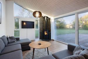 a living room with a couch and a table at Charming Cottage In Fjellerup With Indoor Spa in Glesborg