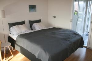 ein Schlafzimmer mit einem großen Bett mit einer schwarzen Decke in der Unterkunft Hammerknuden in Allinge