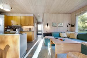 a living room with a couch and a table at Scenic Summer House On Langeland in Humble