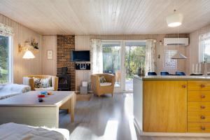 a kitchen and living room with a couch and a table at Scenic Summer House On Langeland in Humble