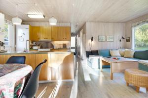 a kitchen and living room with a couch and a table at Scenic Summer House On Langeland in Humble +19 photos