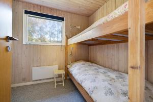 a bedroom with two bunk beds and a window at Scenic Summer House On Langeland in Humble