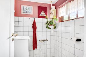 a bathroom with pink walls and white tiles at New Renovated Farmhouse in Slagelse +19 photos