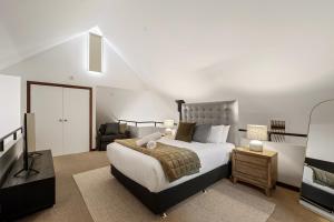 a bedroom with a king sized bed and a chair at Sidney Laine - Family Friendly - Private in Margaret River Town
