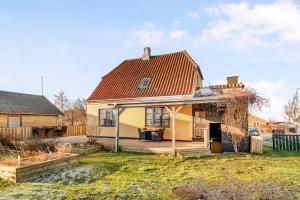 a yellow house with a red roof at Lovely Spacious Holiday Home On Bornholm in Hasle