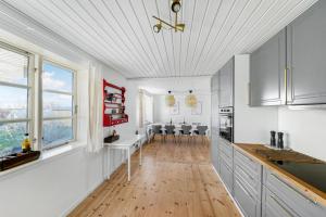 a kitchen with white cabinets and a hard wood floor at Lovely Spacious Holiday Home On Bornholm in Hasle