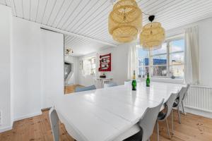 a white dining room with a white table and chairs at Lovely Spacious Holiday Home On Bornholm in Hasle +24 photos