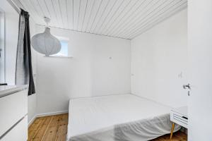 a white bedroom with a bed and a window at Lovely Spacious Holiday Home On Bornholm in Hasle