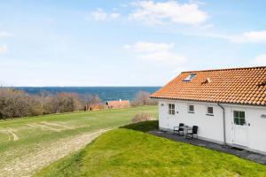 a white house with a grassy yard next to a building at Bornholm Holiday Apartment With Sea View in Allinge
