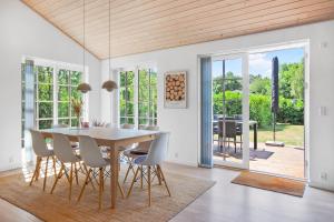a dining room with a table and chairs and a patio at New Modern Holiday Home Near The Beach And City in Nykøbing Sjælland