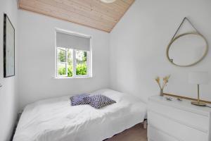 a bedroom with a bed with a mirror and a dresser at New Modern Holiday Home Near The Beach And City in Nykøbing Sjælland