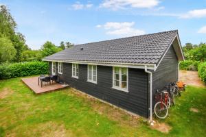 a small black house with bikes parked outside of it at New Modern Holiday Home Near The Beach And City in Nykøbing Sjælland