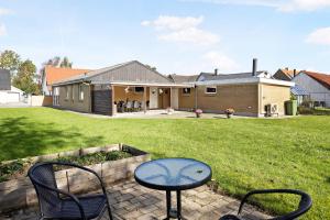 a patio with a table and chairs in a yard at Cozy And Spacious Townhouse In Aars in Års