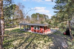 a red house in a field with trees at Family-Friendly Cottage Close To The Water in Nykøbing Sjælland +15 photos