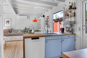 a kitchen with a sink and a living room with a couch at Family-Friendly Cottage Close To The Water in Nykøbing Sjælland