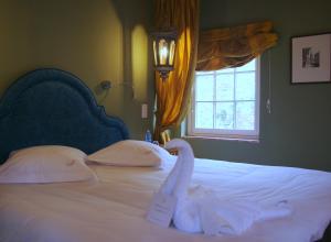 a bedroom with a bed with white sheets and a window at B&B Canal Deluxe in Bruges