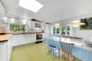 une cuisine avec une table et des chaises bleues dans l'établissement Cottage On Fur Island With Exceptional Sea View, à Fur