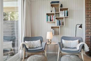 two chairs and a lamp in a room with a window at Bright And Cozy Summer House With Sea View in Hasle