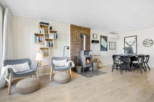 a living room with a fireplace and a table and chairs at Bright And Cozy Summer House With Sea View in Hasle