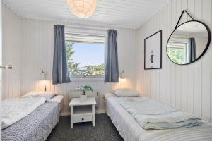 two beds in a room with a mirror and a window at Bright And Cozy Summer House With Sea View in Hasle +11 photos