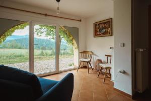 a living room with a window and a table and chairs at Kmetija Pečnik in Prevalje