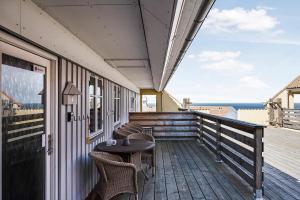 a patio with a table and chairs on a deck at Holiday Apartment With Pool On Bornholm in Gudhjem