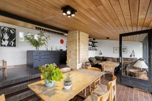 a living room with a table and a couch at Architect Designed Holiday Home With Sea View in Gudhjem +16 photos