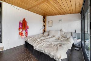 a bed in a room with a wooden ceiling at Architect Designed Holiday Home With Sea View in Gudhjem